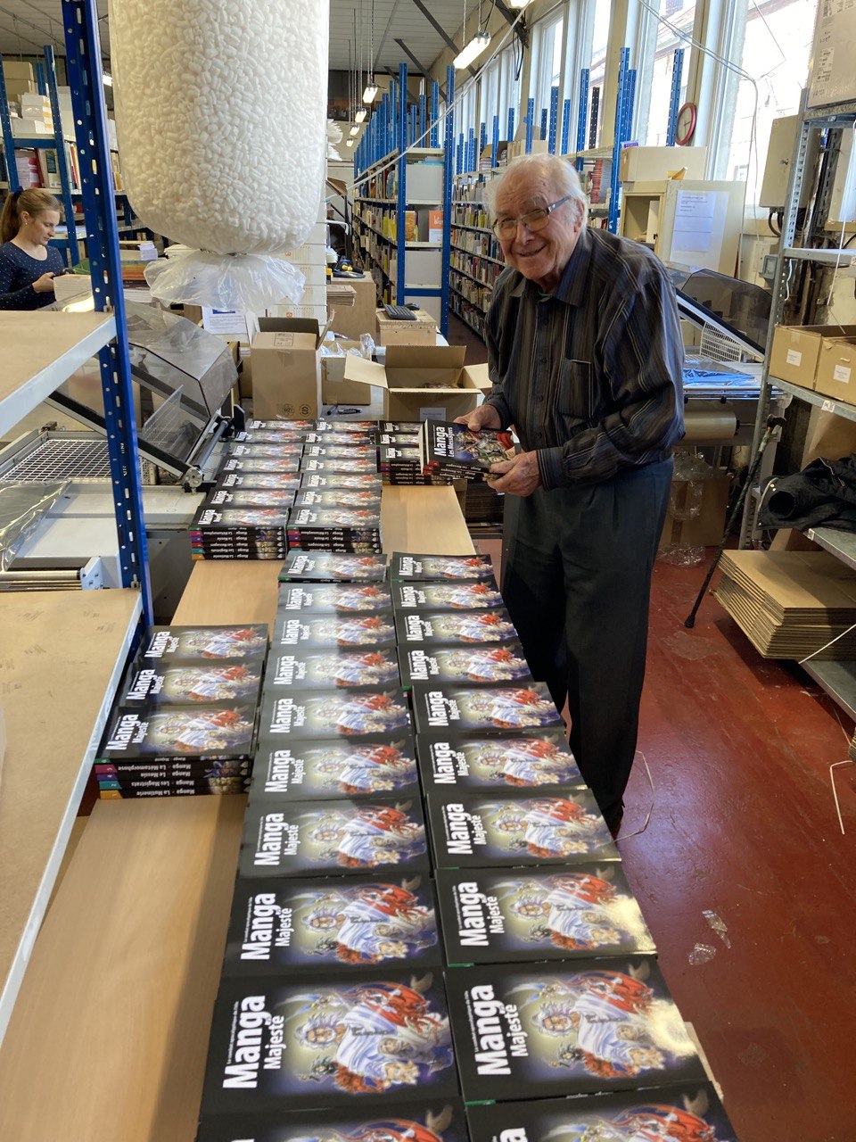 A person handling rows of books at a table inside the BLF warehouse
